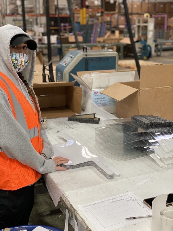 Landaal Packaging employee wearing face mask assembles face shields and PPE for donation to local essential workers fighting COIVD-19.